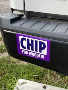 Chip for Woodfin purple bumper stickers on a truck's bumper.